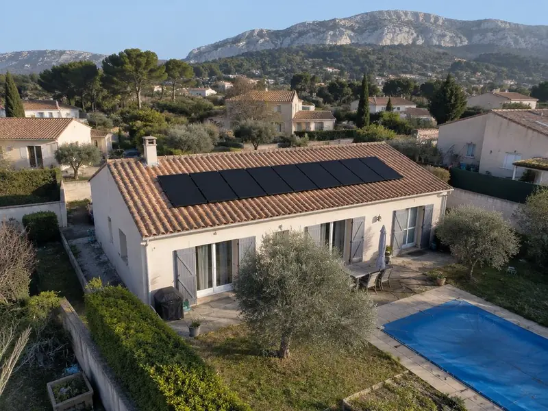 Maison provençale avec panneaux solaires noirs sur toiture en tuiles