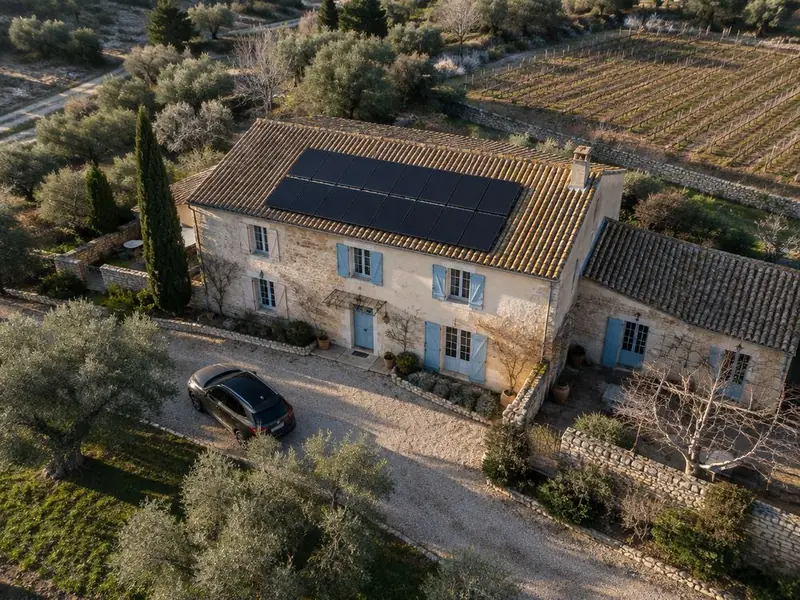 Maison provençale avec panneaux solaires noirs sur toiture en tuiles